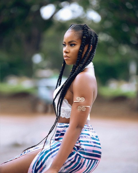 a woman with braids sitting on a bench