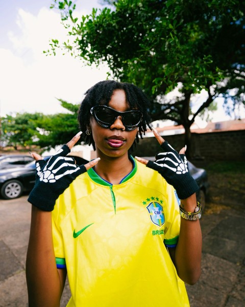 a woman wearing a yellow shirt and black gloves