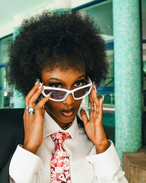 a woman wearing a tie and sunglasses in2d