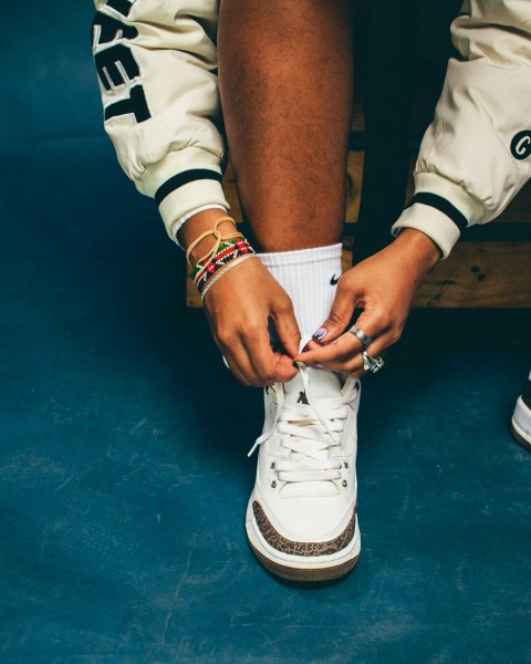 a person tying a pair of white sneakers