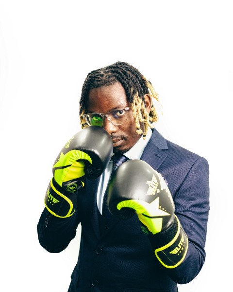 a man in a suit and tie wearing boxing gloves