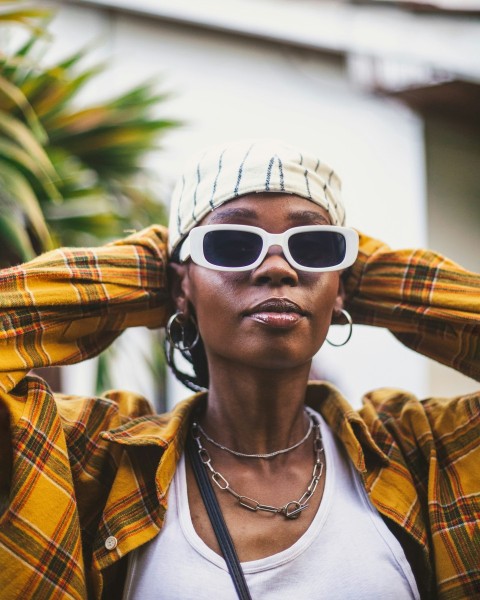 a woman wearing sunglasses and a plaid hat