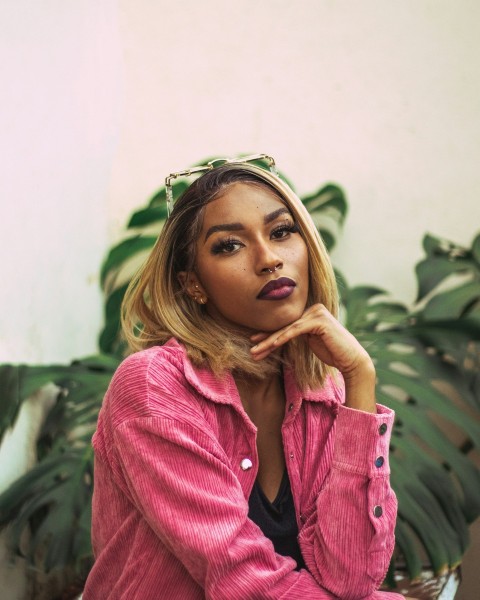 a woman in a pink shirt sitting on a bench