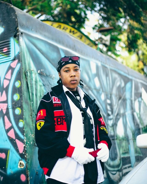 a man standing in front of a graffiti covered wall