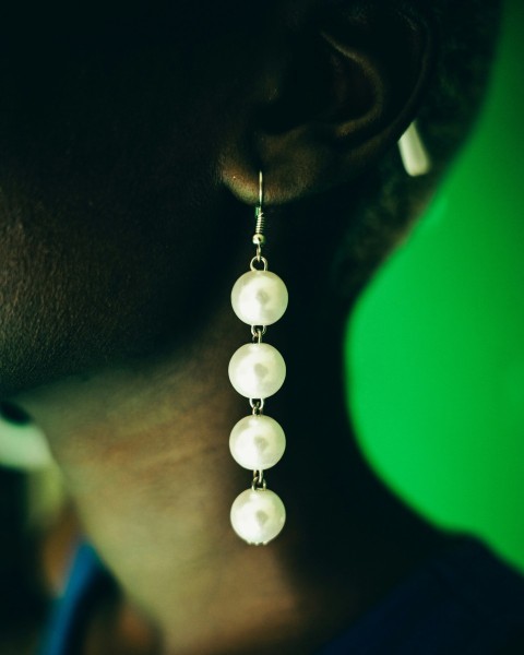 a close up of a person wearing a pair of earrings