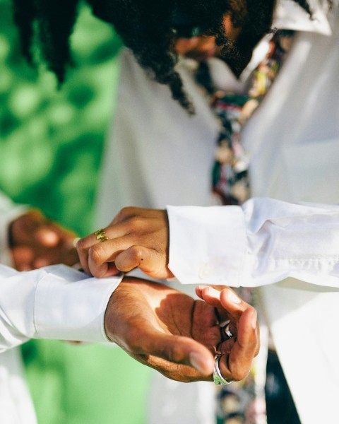 a man putting a ring on another mans finger