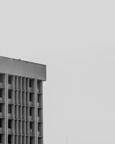 a black and white photo of a building and a plane