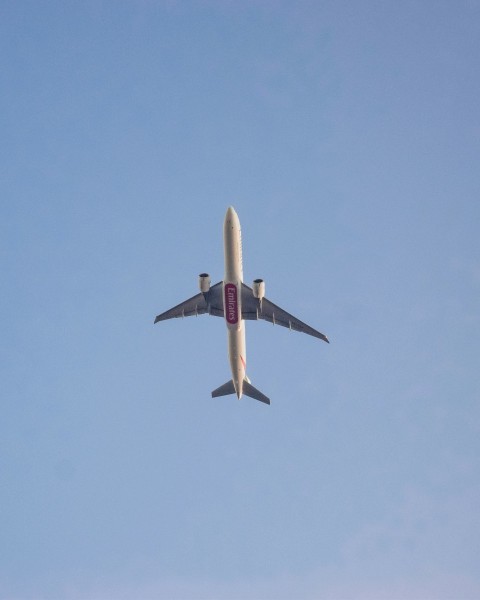 white and red airplane in mid air during daytime