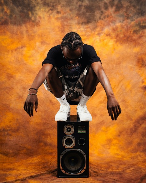 a man sitting on top of a speaker tbz5