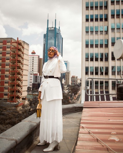 a woman in a white dress standing on a roof