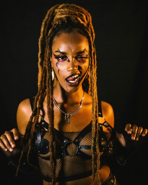 a woman with makeup on her face and dreadlocks