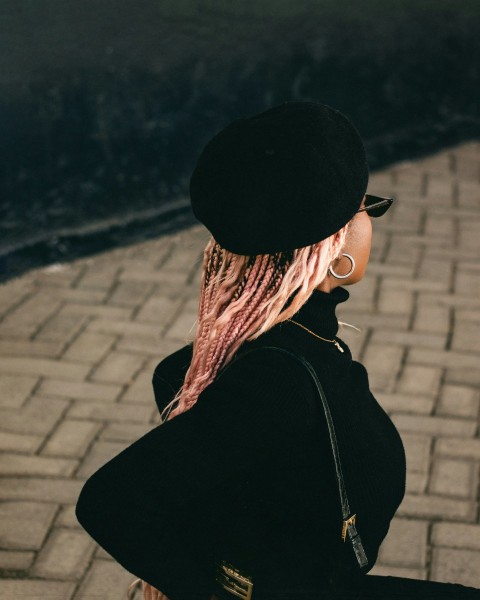 a woman with pink hair walking down a sidewalk