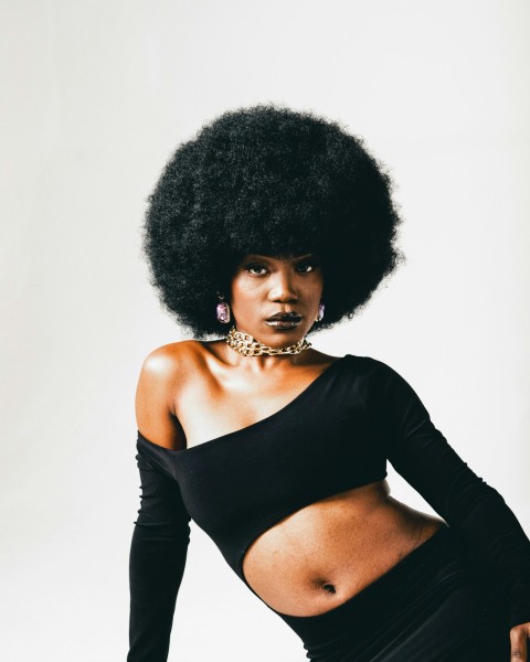 a woman with an afro is posing for a picture