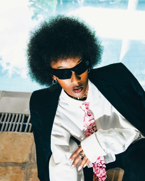 a woman with an afro wearing a suit and tie