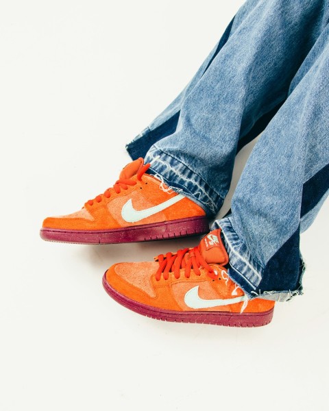 a pair of jeans and a pair of orange sneakers