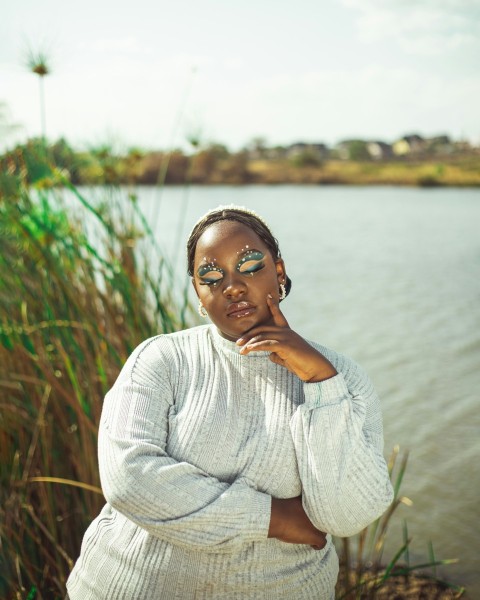 a woman standing next to a body of water