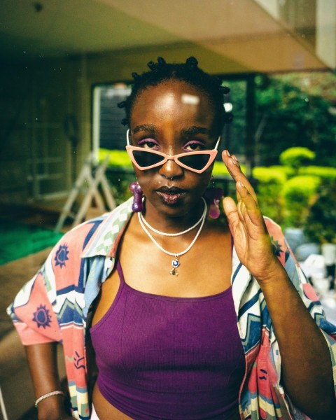 a woman wearing pink glasses and a purple top