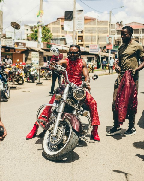 a woman in a red dress sitting on a motorcycle