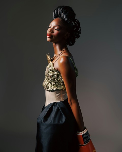 a woman in a black dress holding a red bag