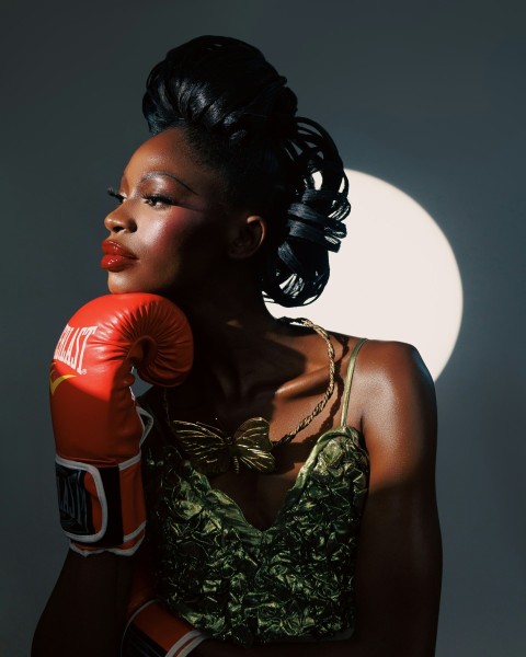 a woman in a green dress and red boxing gloves