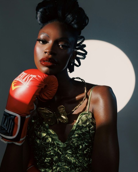 a woman in a green dress with a red boxing glove