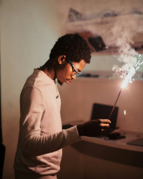 a man holding a lit sparkler in his hand