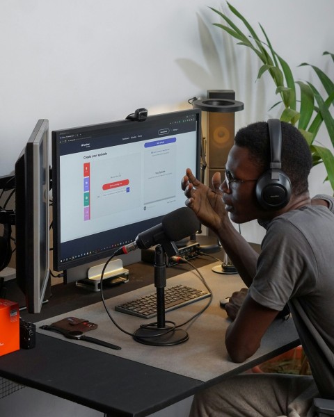 a man wearing headphones sitting in front of a computer