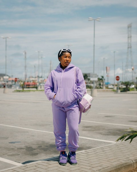 a woman in a purple outfit is standing in a parking lot 8