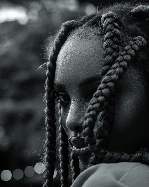 a black and white photo of a woman with dreadlocks e