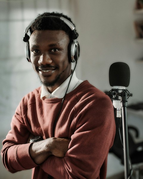 a man wearing headphones standing in front of a microphone 6BWFAPPWn