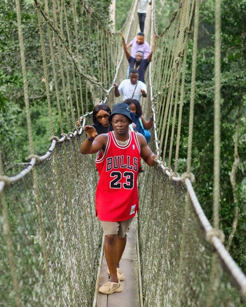 a group of people walking across a suspension bridge