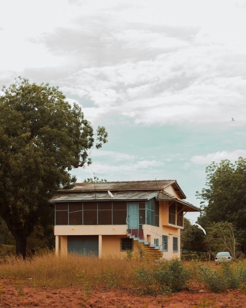 brown and white wooden house surrounded by green trees under white clouds during daytime _2