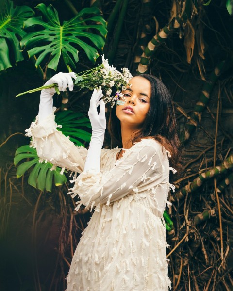 a woman in a white dress holding a bouquet of flowers