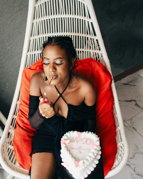 a woman sitting in a chair with a heart shaped cake lH