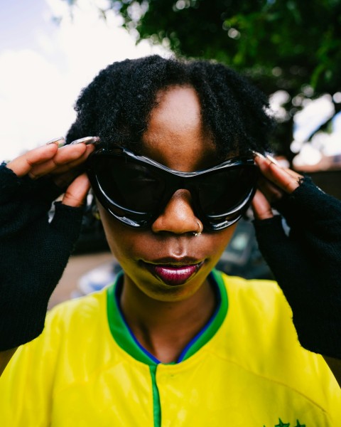 a woman wearing sunglasses and a yellow shirt DMeDcn0