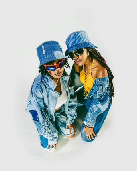 two young women wearing hats and jeans posing for a picture