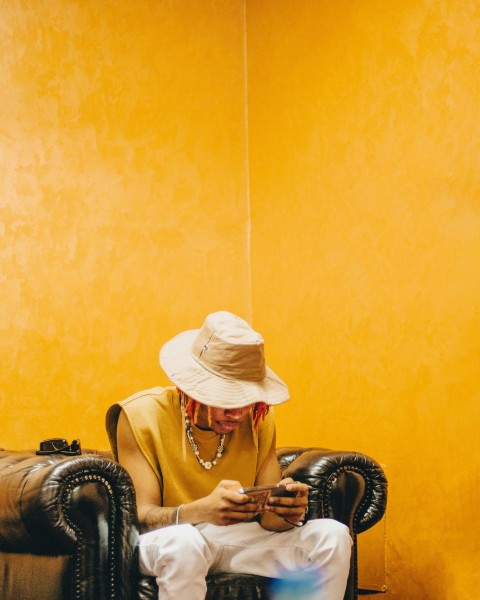 a man sitting in a chair looking at his cell phone o