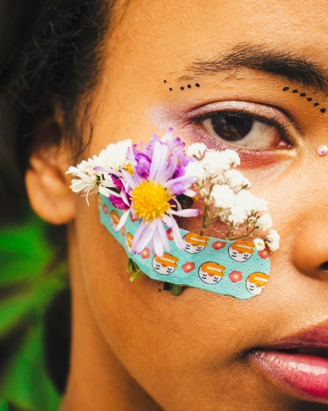 a close up of a person with a flower on their forehead