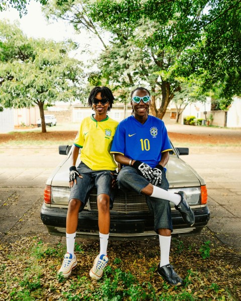 a couple of people sitting on the back of a car Vke5