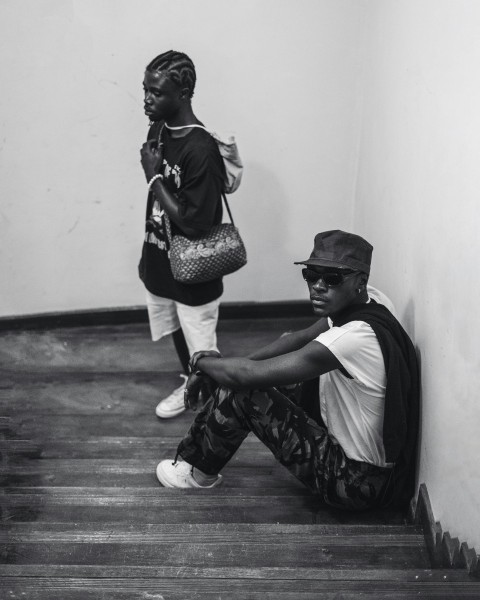 a black and white photo of two people sitting on stairs