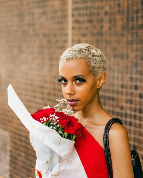 a woman in a red dress holding a bouquet of flowers