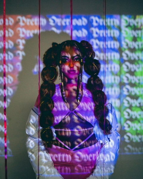 a woman with long hair standing in front of a screen