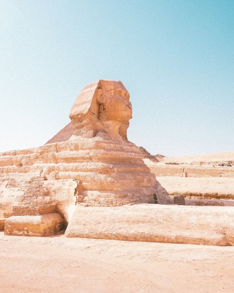 a large sphinx statue sitting in the middle of a desert