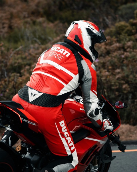 a man riding a red motorcycle down a street jezg3mGHF