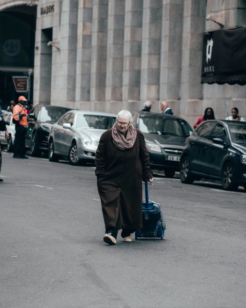 woman in black dress standing on road during daytime