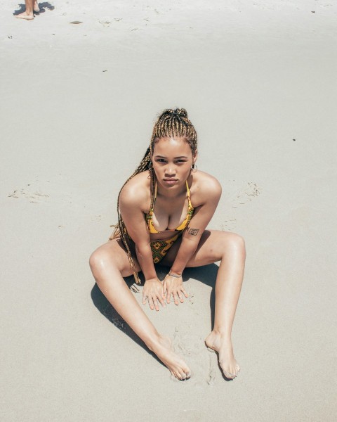 woman in yellow bikini sitting on sand during daytime