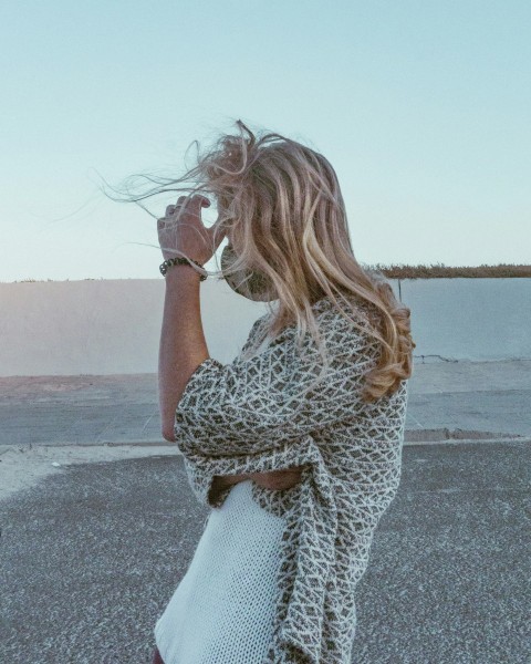 woman in black and white leopard print long sleeve shirt and white pants sitting on gray