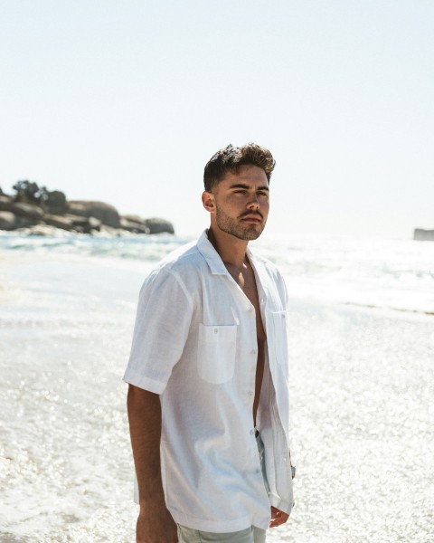 a man standing on a beach next to the ocean