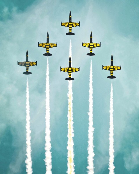 a group of fighter jets flying through a blue sky