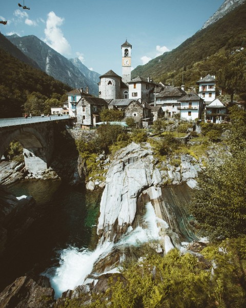 white concrete building on cliff near river during daytime